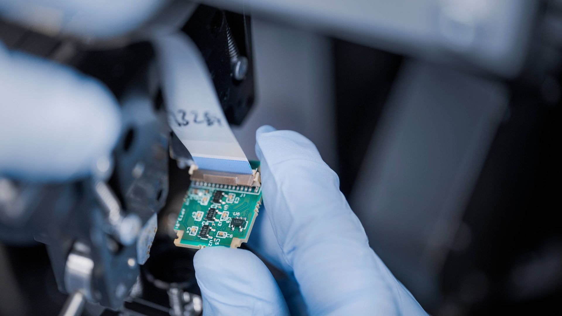 A person looking at a small circuit board 